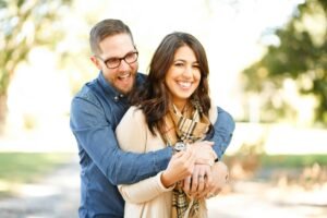 Un couple heureux profitant d'une séance photo de fiançailles en plein air avec rire et amour.